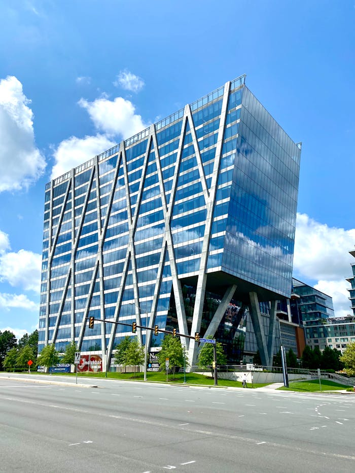 About A striking modern office building with a geometric glass facade in an urban setting.